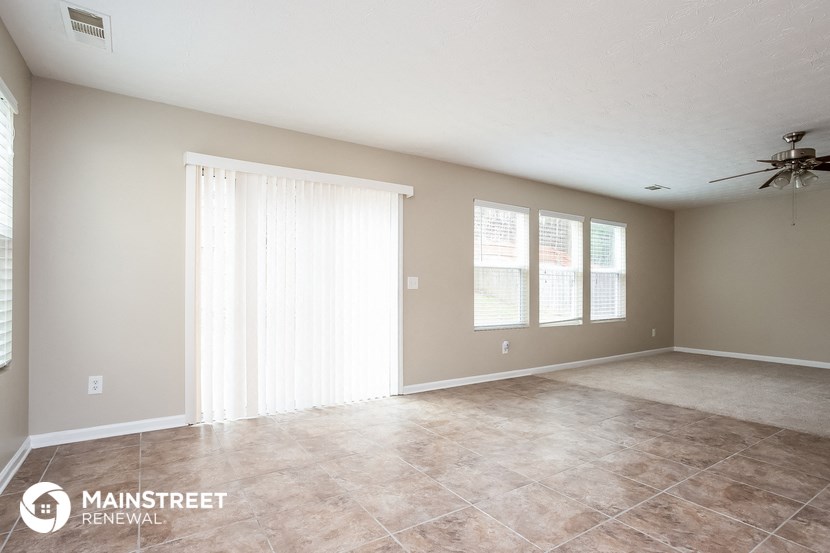 the living room of an empty house with a large window