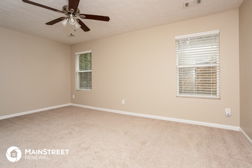 the living room of an empty house with a ceiling fan