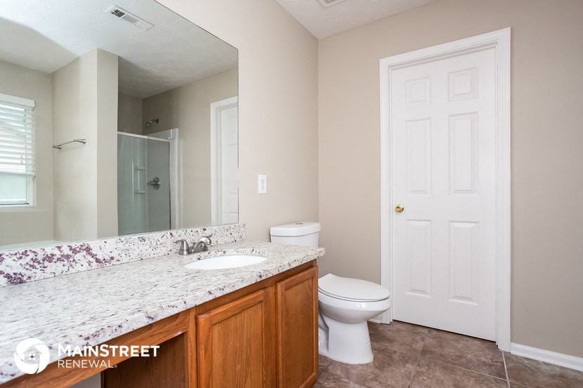a bathroom with a toilet and a sink and a mirror
