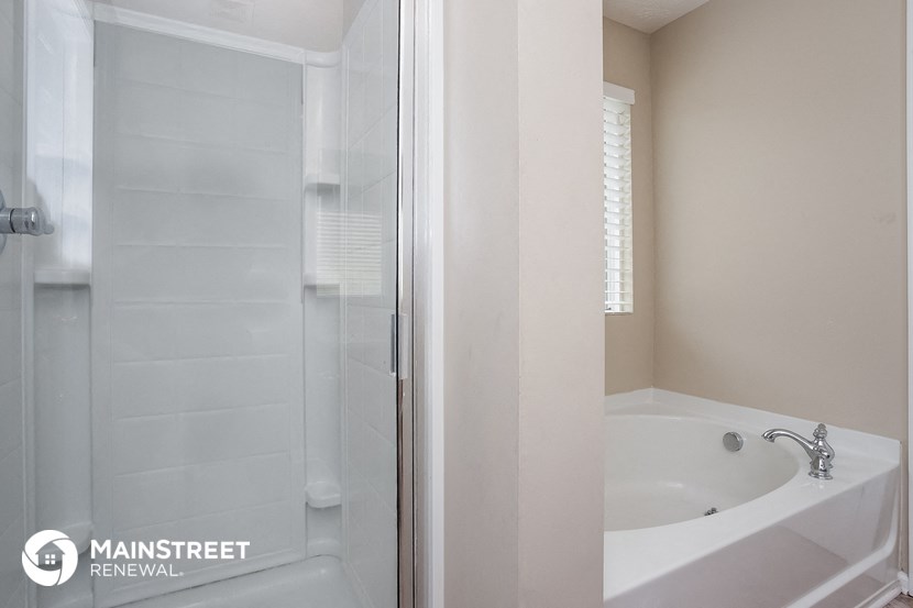 a bathroom with a tub and a shower and a sink