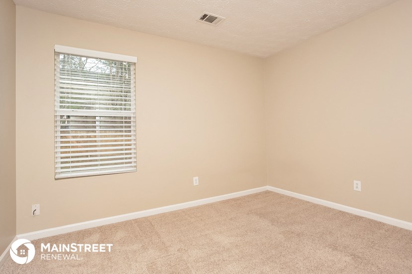 the upstairs bedroom with carpet and a window