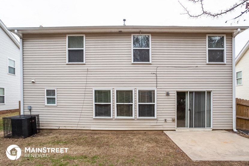 the exterior of a white house with white siding and a driveway