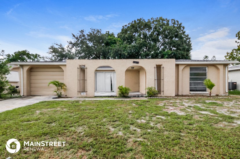 a beige house with a yard and a white door
