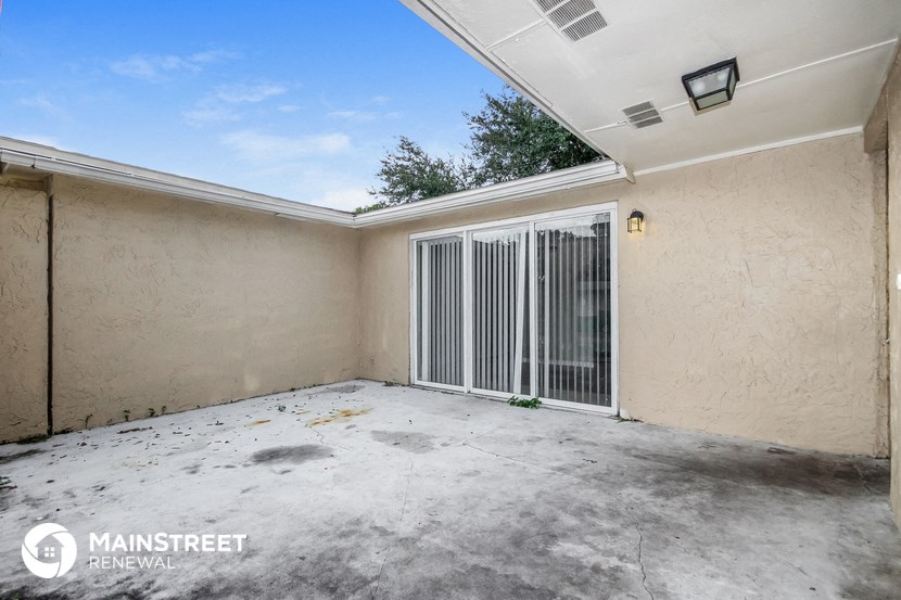 the garage of a house with a patio and a gate