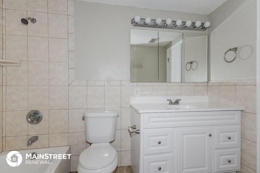a bathroom with a sink toilet and a mirror