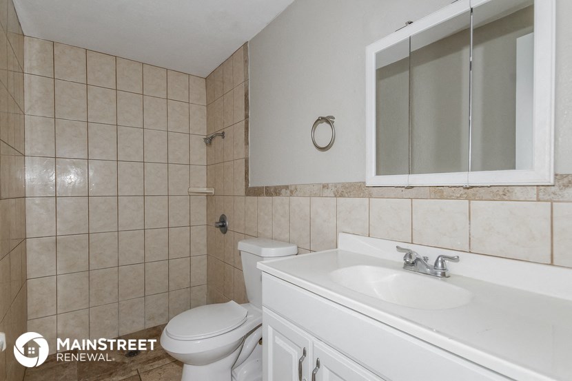 a bathroom with a sink toilet and a mirror