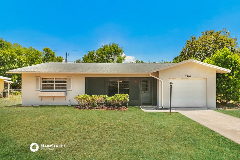 a white house with a lawn and a garage door