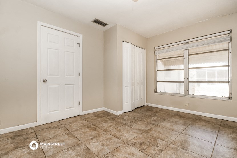 an empty living room with two doors and a window