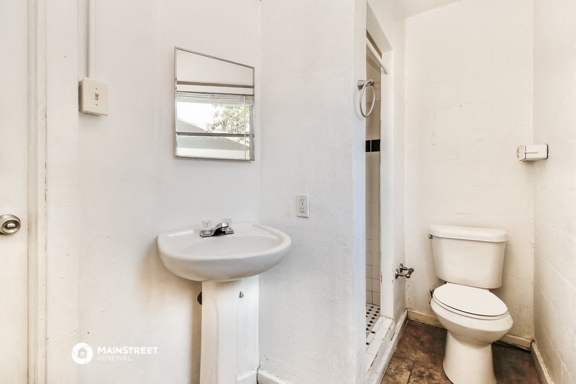a bathroom with a toilet and a sink and a mirror