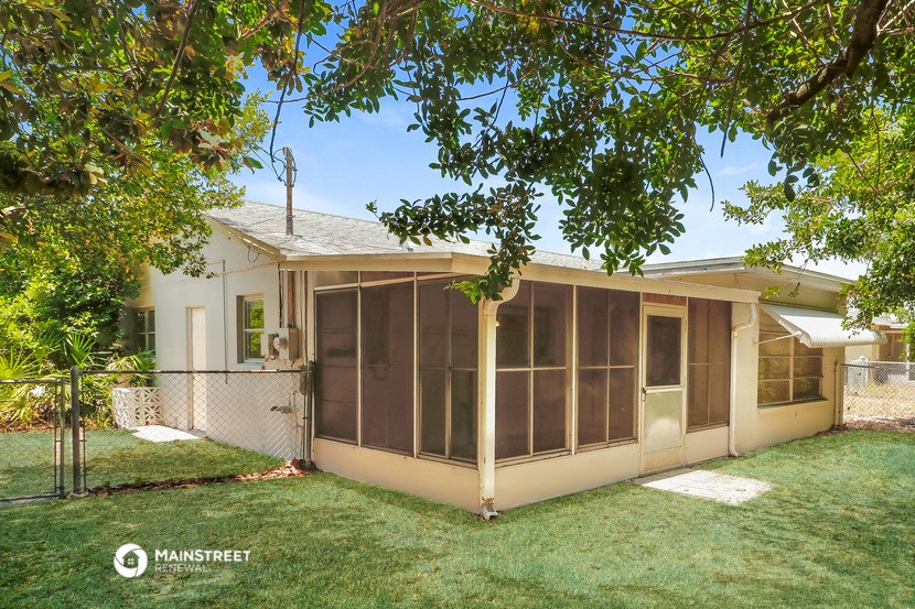 a small house with a yard and a tree
