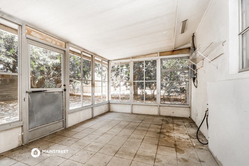 an empty room in a house with windows and a door