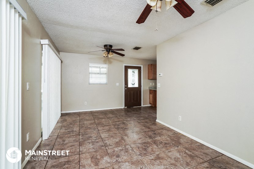 the living room is spacious and has a ceiling fan