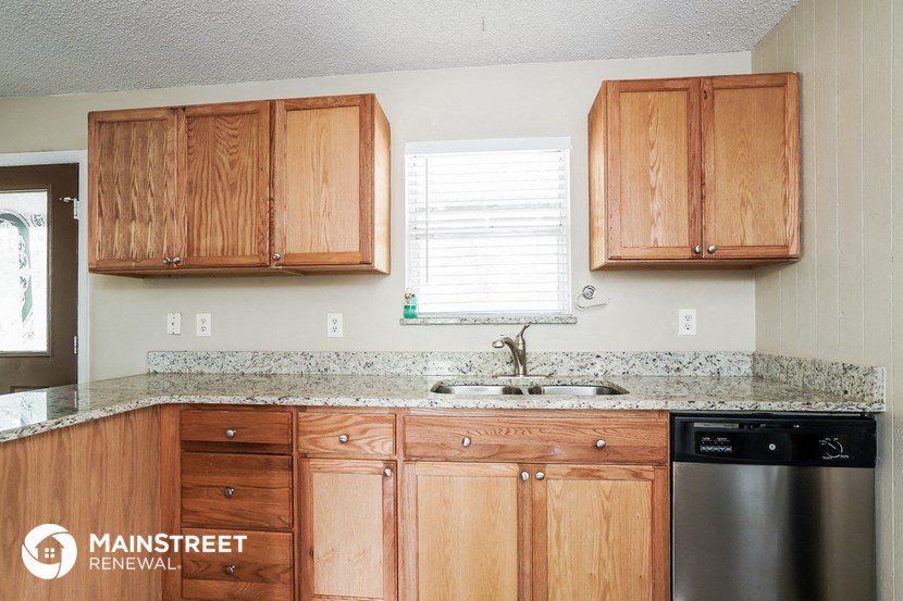 a kitchen with wooden cabinets and a sink and a window