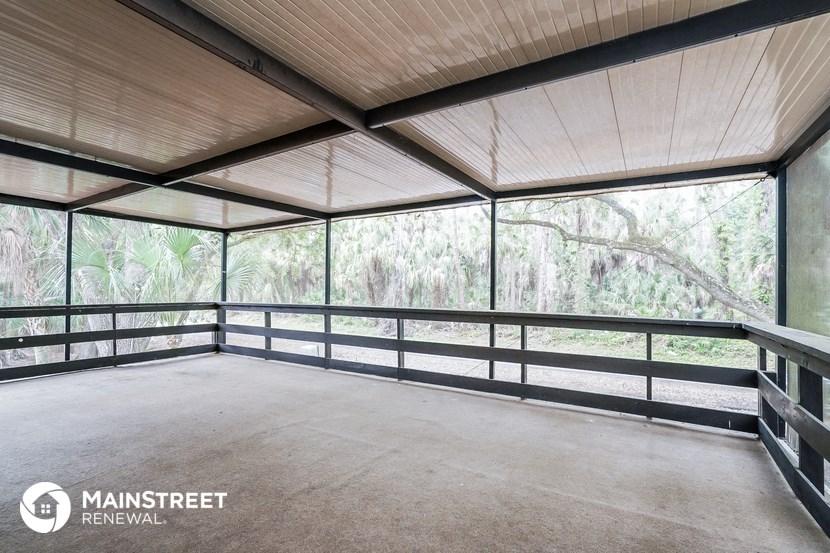 a large screened porch with a view of the forest