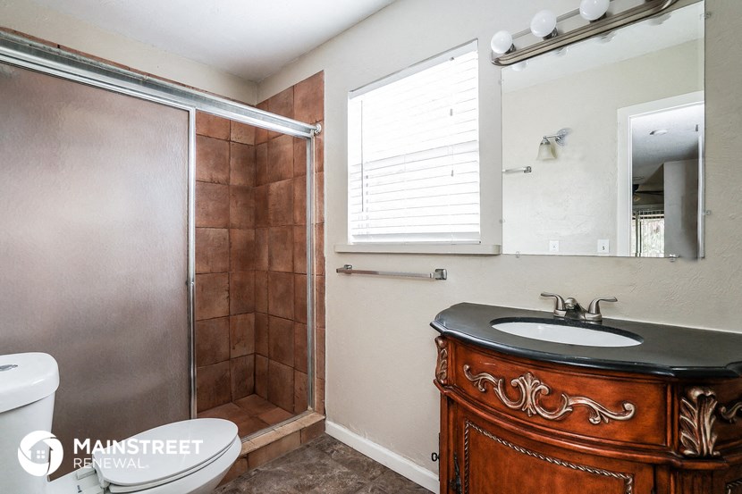 a bathroom with a shower and a sink and a mirror