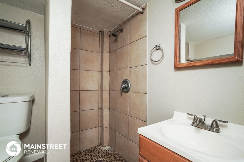 a bathroom with a shower and a sink and a mirror