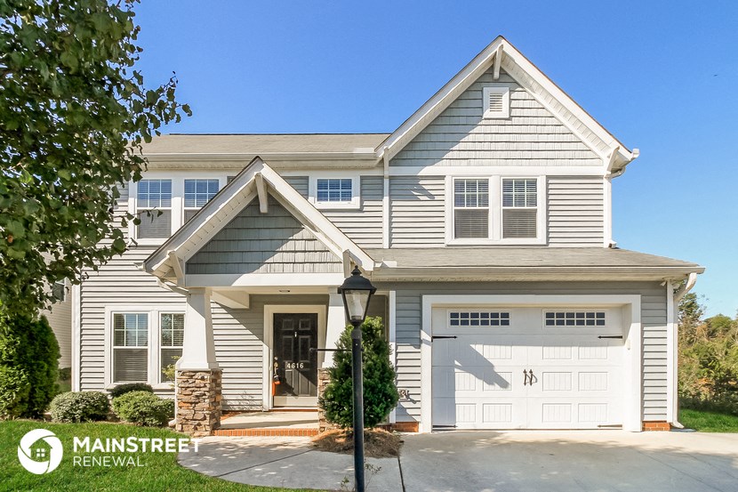a white house with a white garage door and a street light