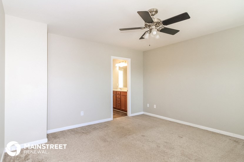 a bedroom with a ceiling fan and a closet