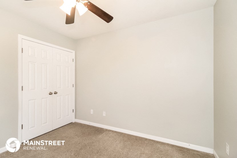 the upstairs bedroom has a closet and a ceiling fan