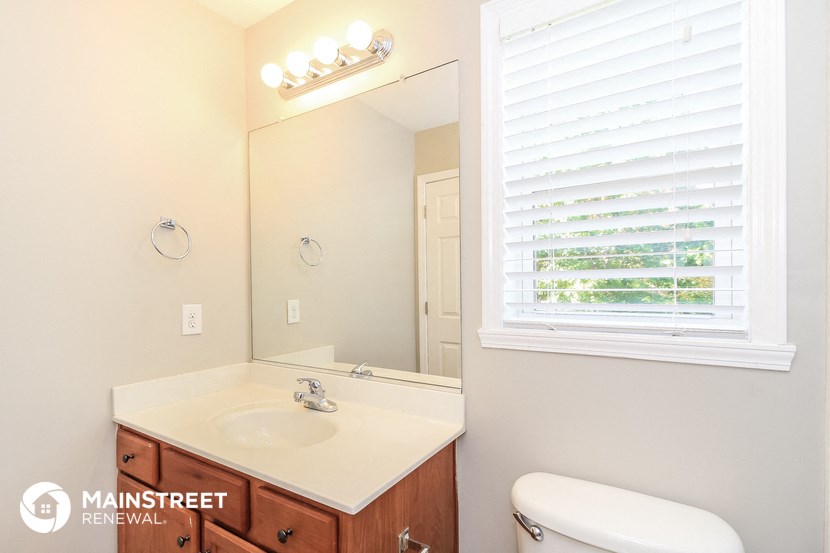 a bathroom with a mirror and a sink and a toilet