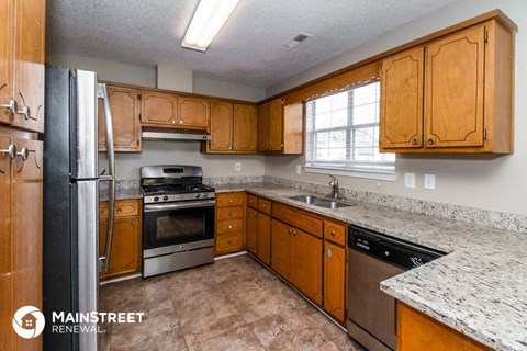 a kitchen with wooden cabinets and stainless steel appliances