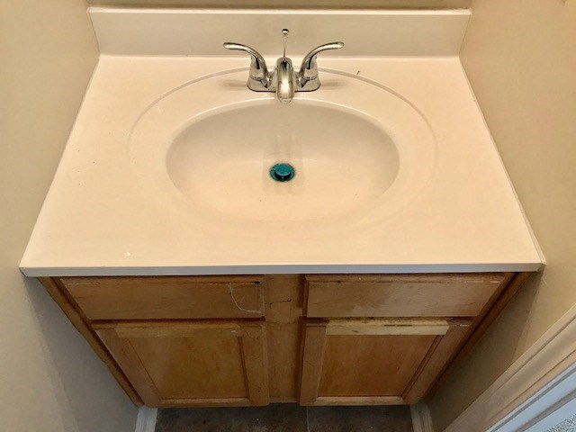 a white sink in a bathroom with a faucet