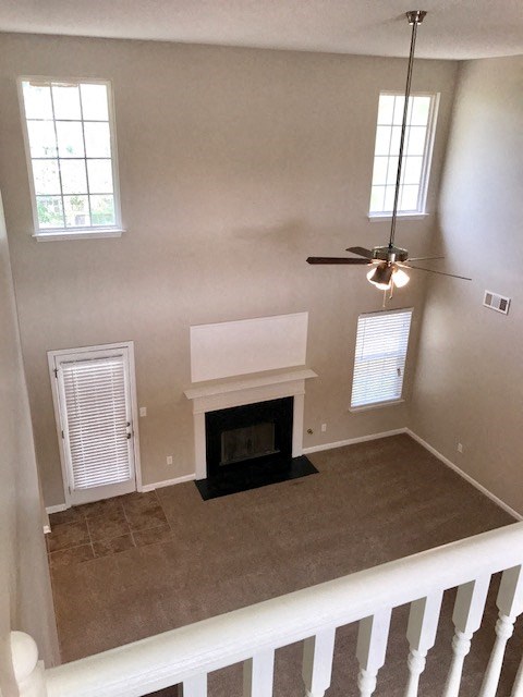 a living room with a fireplace and a ceiling fan