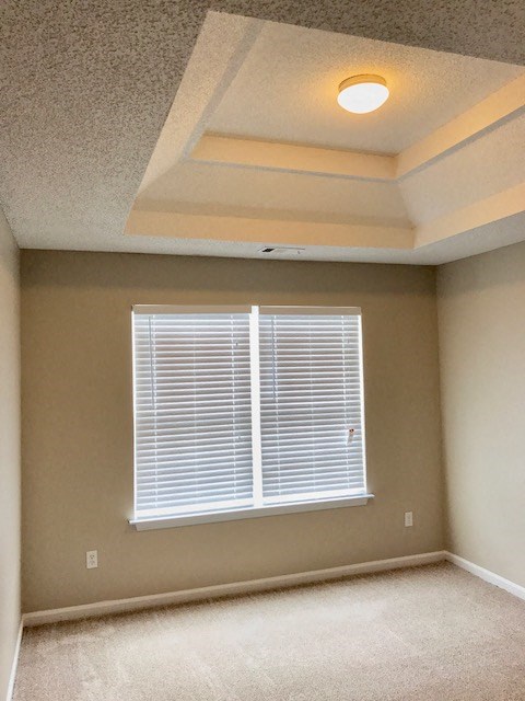 an empty room with a window and a light on the ceiling