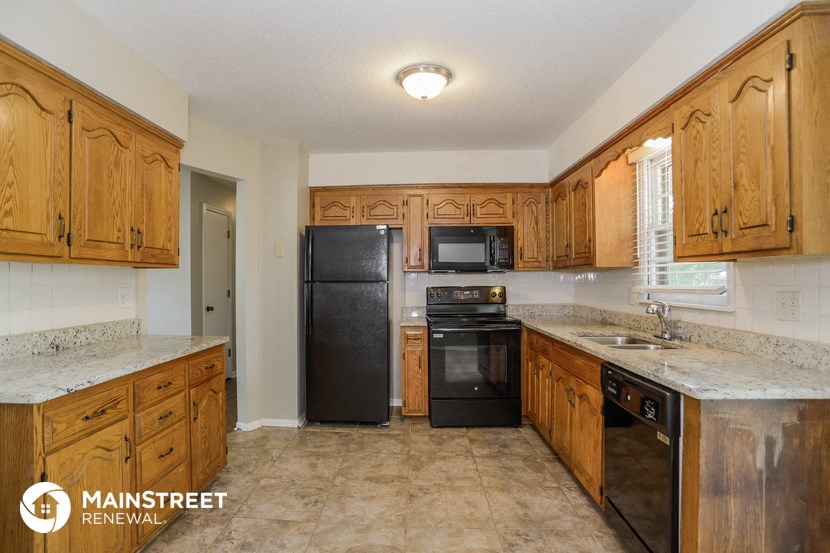 a kitchen with wooden cabinets and black appliances