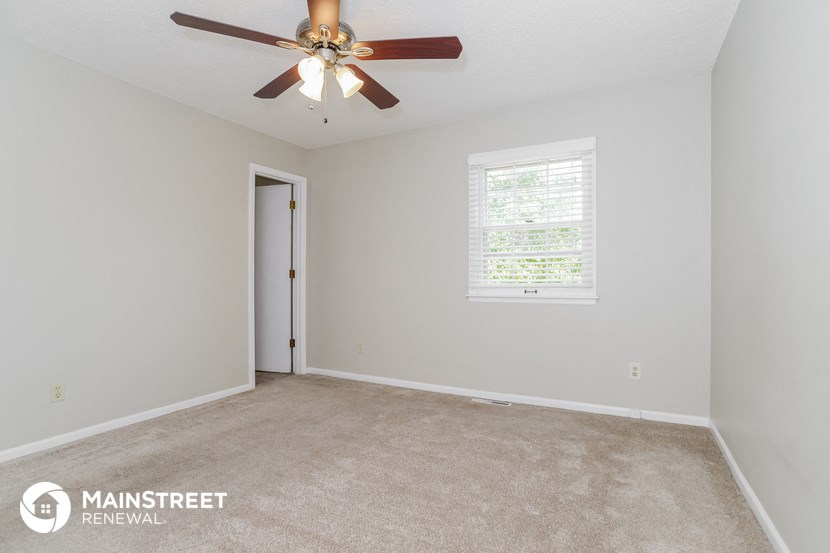 an empty room with a ceiling fan and a window