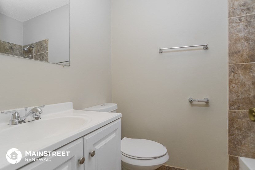a bathroom with a sink toilet and a mirror
