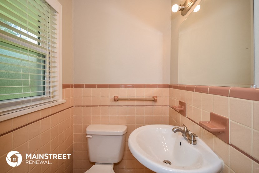 a bathroom with a sink and a toilet and a window