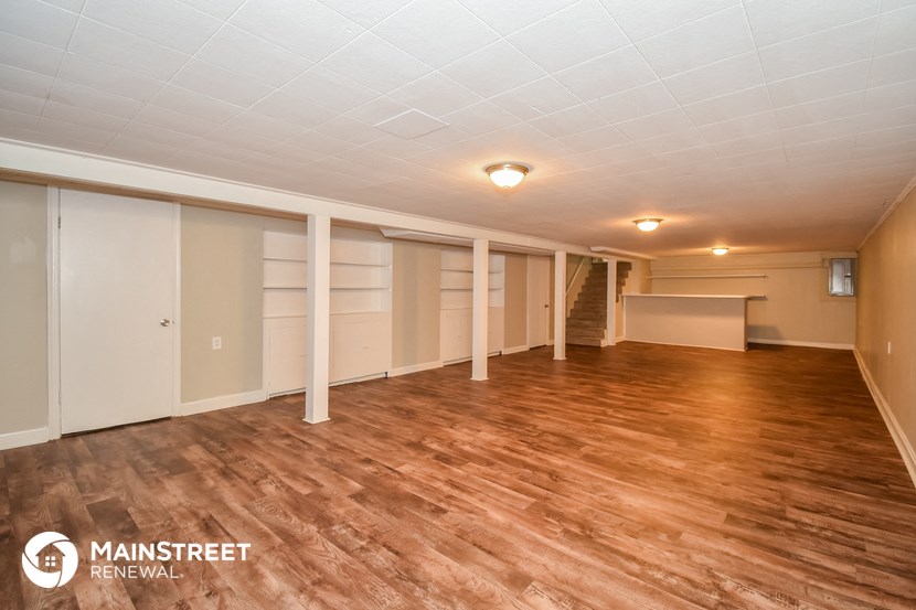 an empty living room with wood floors and white walls