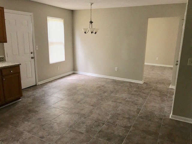 an empty living room with tile floors and a white door