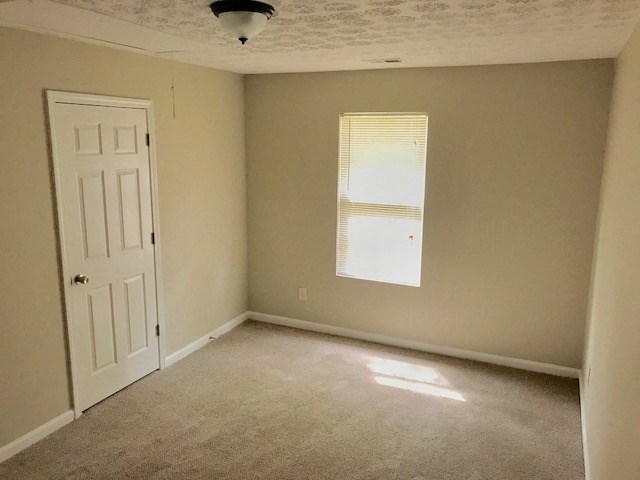 an empty room with a window and a white door