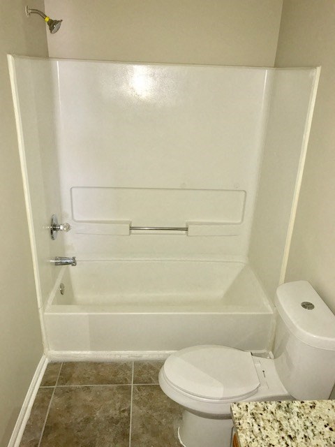 a white bathroom with a toilet and a bath tub