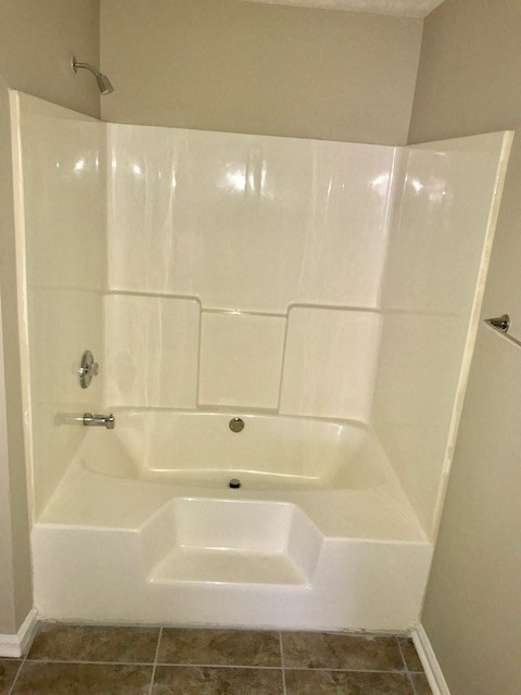 a white bathroom with a shower and a toilet