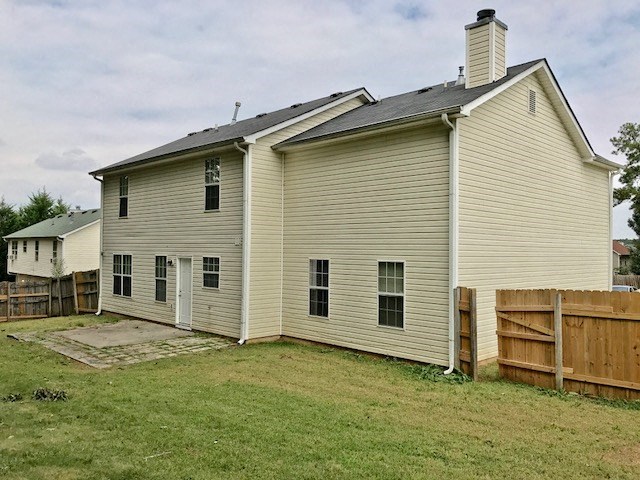 a white house with a yard and a wooden fence