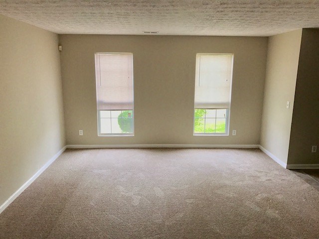 an empty room with two windows in it