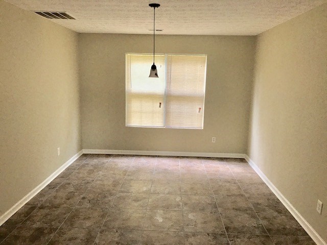 an empty room with a window and a chandelier