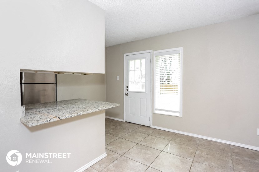 a kitchen with a counter and a door to a refrigerator