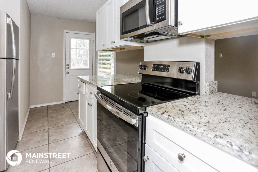 the kitchen has granite counter tops and stainless steel appliances