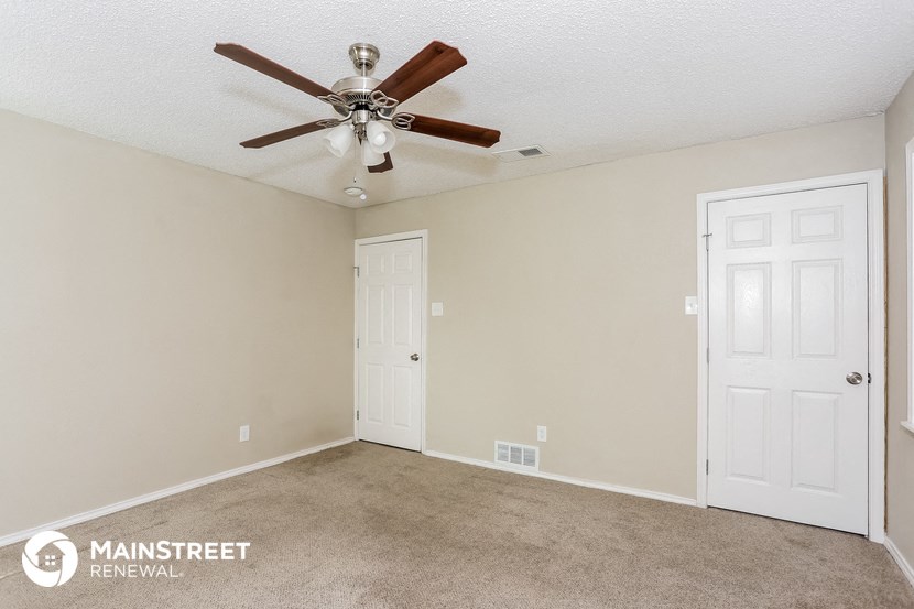 the living room of this home has a ceiling fan and a carpet