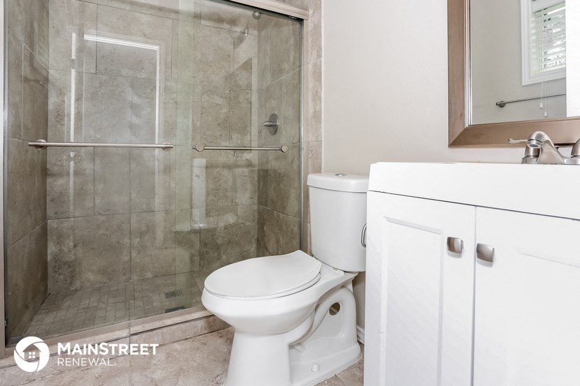 a bathroom with a shower and a toilet and a sink