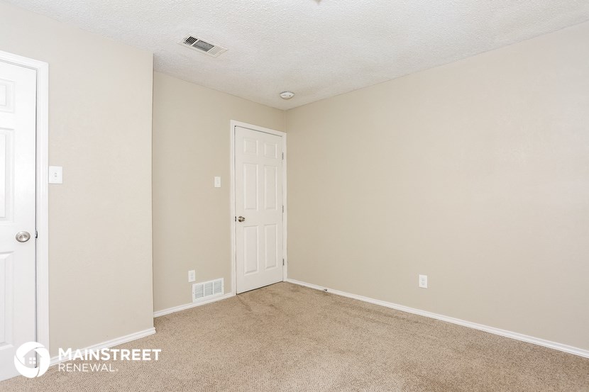 a bedroom with a white door and a carpeted floor