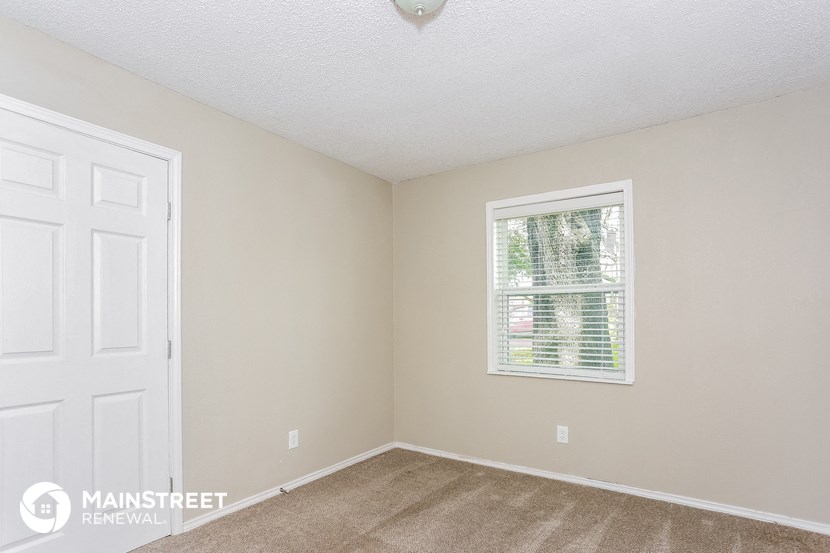 a bedroom with a window and a white door