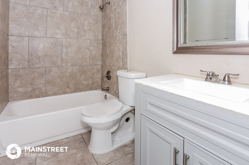 a bathroom with a toilet and a sink and a bath tub