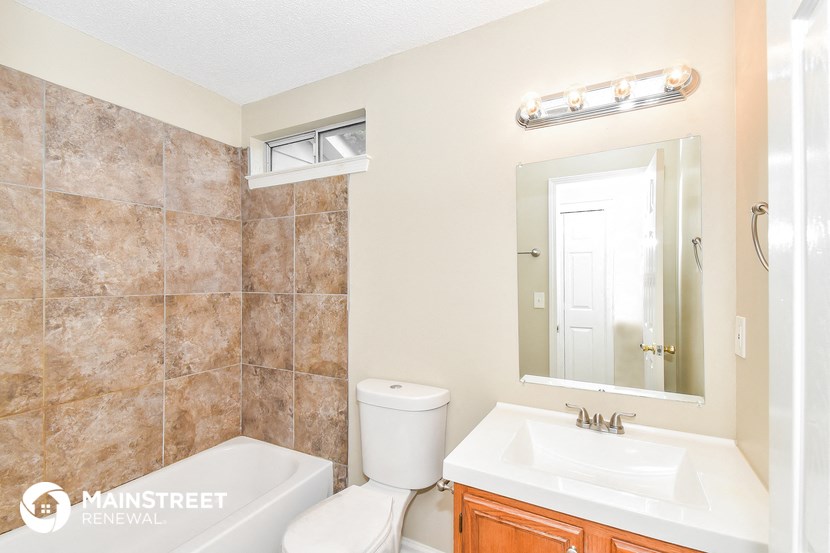 a bathroom with a sink toilet and a mirror
