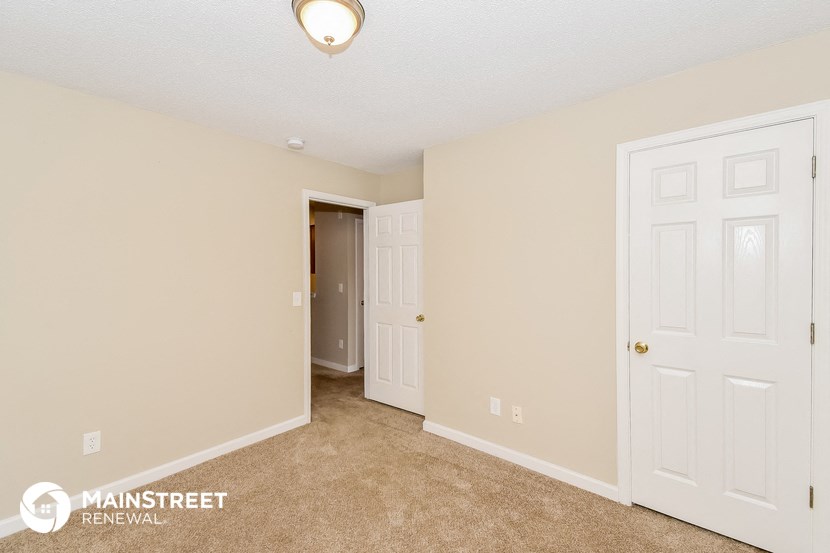 a bedroom with two closets and a door to a hallway
