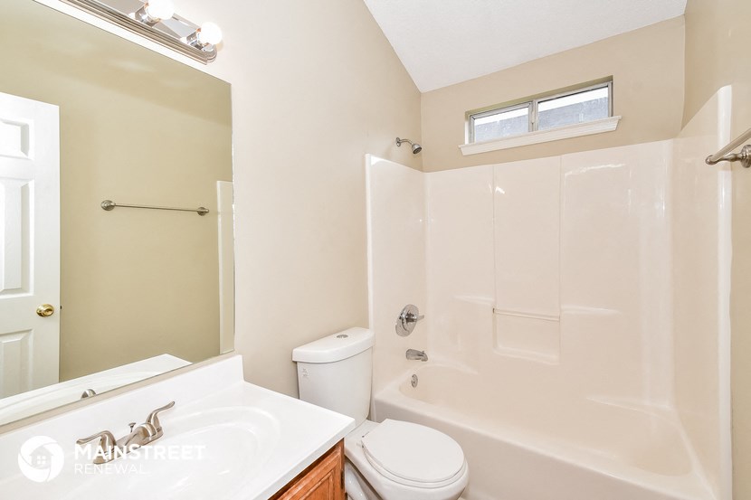 a bathroom with a shower and a sink and a toilet